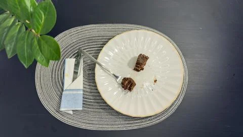 Empty dirty white plate with cake crumbs and fork after finishing dessert, .. Stock-Fotos
