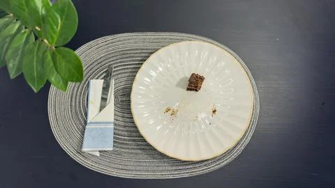 Empty dirty white plate with cake crumbs and fork after finishing dessert, .. Stock-Fotos