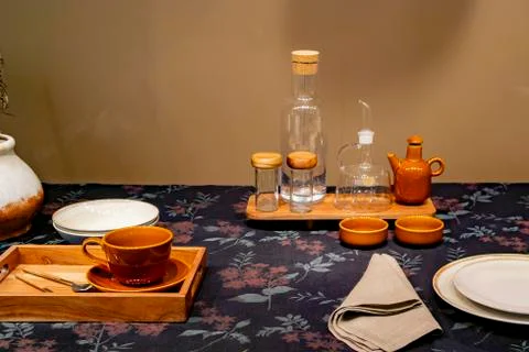 Empty dishes are on the table on a black flowered tablecloth Stock Photos