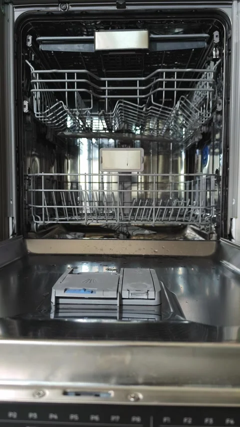 Empty dishwasher racks stand open inside kitchen appliance after unloading... Stock Footage 345552575