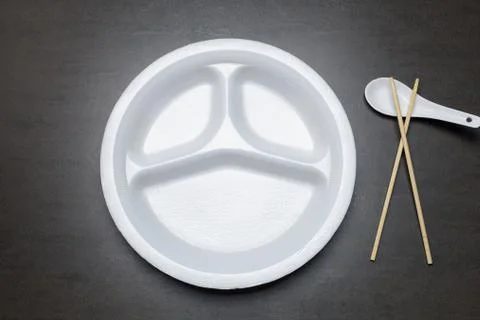 Empty disposable plastic plate on black table. Stock Photos