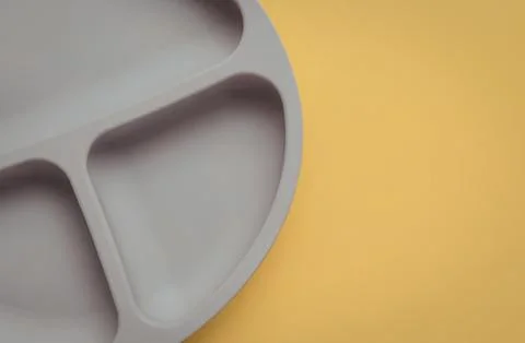Empty divided plastic plate on yellow background Stock Photos