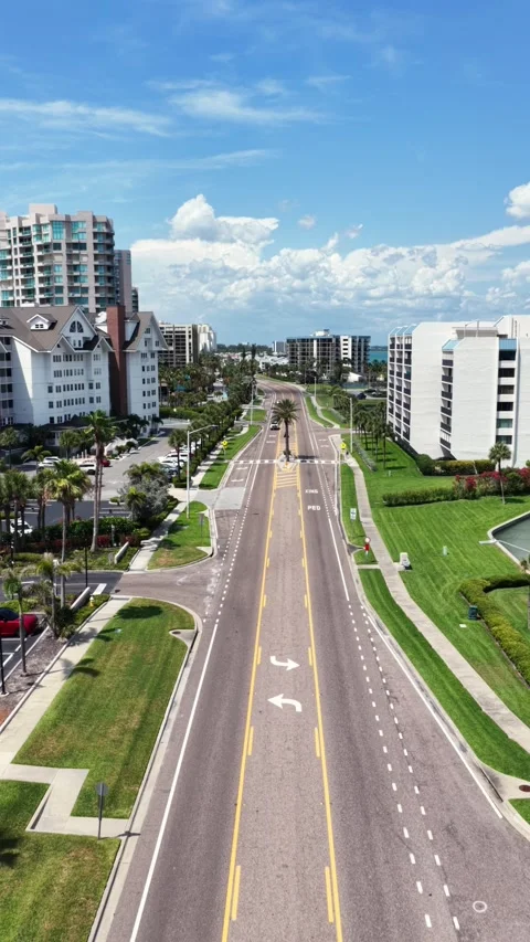 Empty divided road stretches toward high-rise condos along Gulf coast in Stock Footage 340114922
