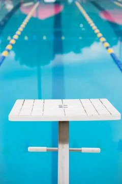 Empty diving block looking down pool race lane Stock Photos