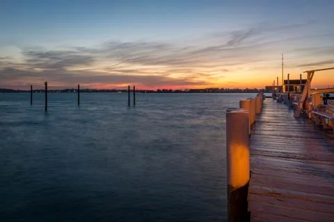 Empty Dock Extending into a Harbor at Sunset Stock Photos