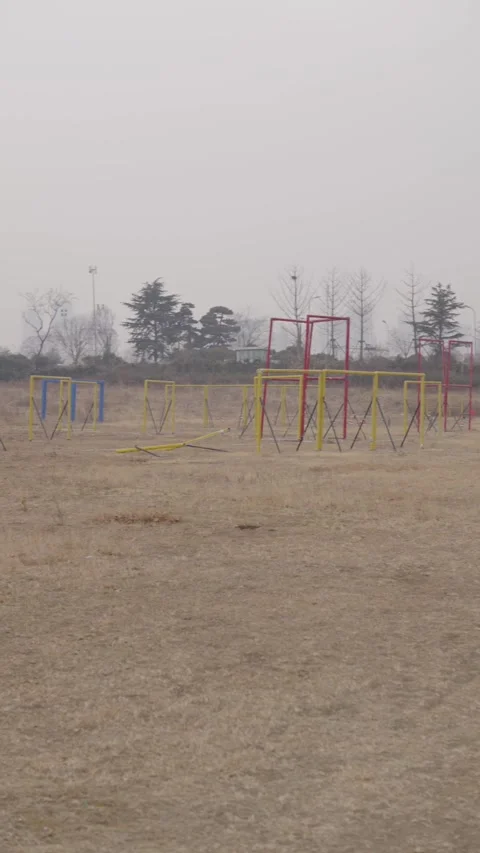 Empty dog agility training equipment sitting in an abandoned field on a gloomy, Stock Footage 328987178