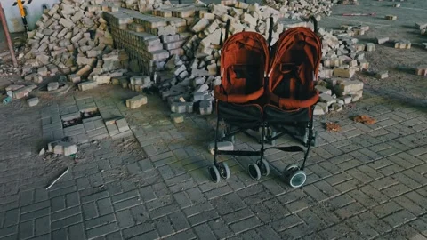 An empty double baby stroller parked near a construction site. Video stock 346080036
