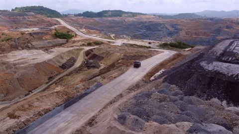 Empty dump truck drives on large excavation site, open pit mine, aerial orbit Stock Footage 309114704