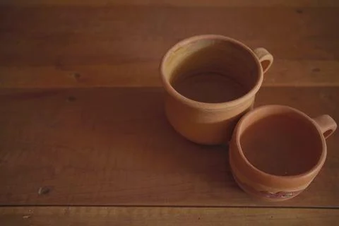 Empty earthenware mug on wooden table background. Stock Photos
