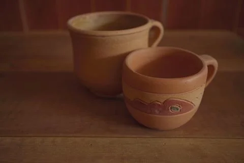 Empty earthenware mug on wooden table background. Stock Photos