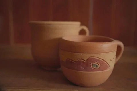 Empty earthenware mug on wooden table background. Stock Photos