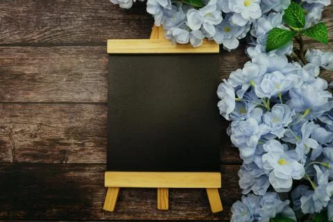 Empty Easel Space copy for text with Blooming flowers on wooden background Stock Photos