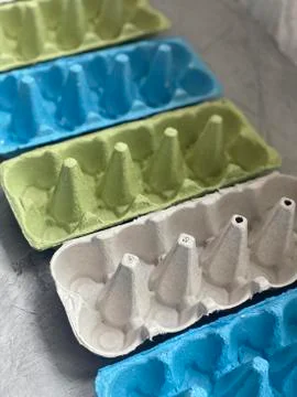 Empty egg boxes of three colors, on a gray background, Stock Photos