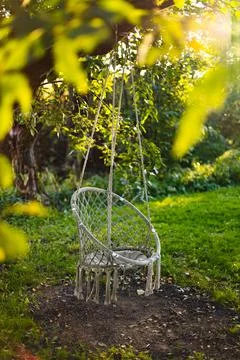 Empty egg chair with tinsels on tree branch in spring garden Stock Photos