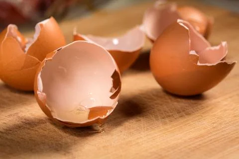 Empty egg shells on wooden cutting board Stock Photos