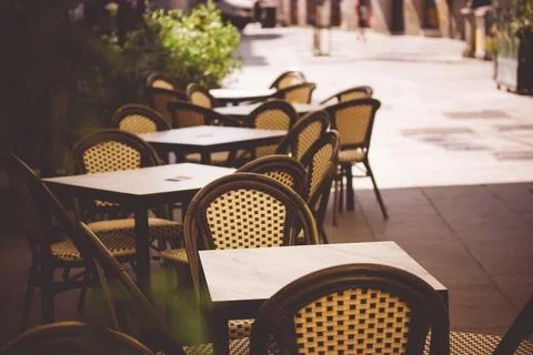 Empty elegant old-fashioned coffee terracce with tables and chairs on an old Stock Photos