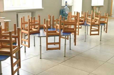Empty elementary classroom with colorful tables and small chairs on top, Photos