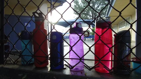 Empty Elementary School Water Bottles Seen Through Chainlink Fence Stock Footage 130677681