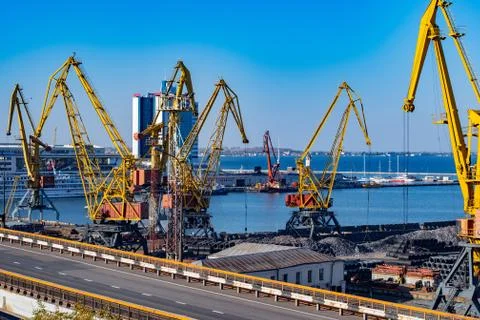 Empty elevated road and industrial port landscape with yellow metal crane jibs Foto stock