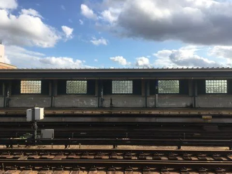 Empty elevated subway platform with subway tracks in foreground. Stock Photos