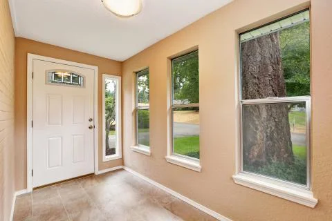 Empty entryway with tile floor, beige walls and white front Northwest, USA. Stock Photos