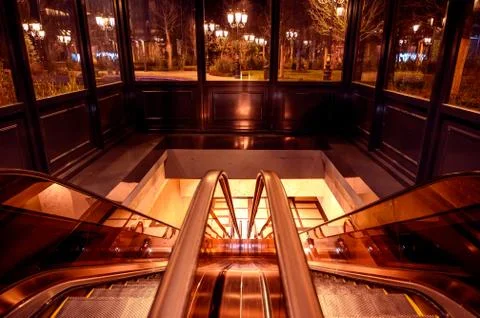 An empty escalator with backlight. Symmetrical rolling stairs. Stock Photos
