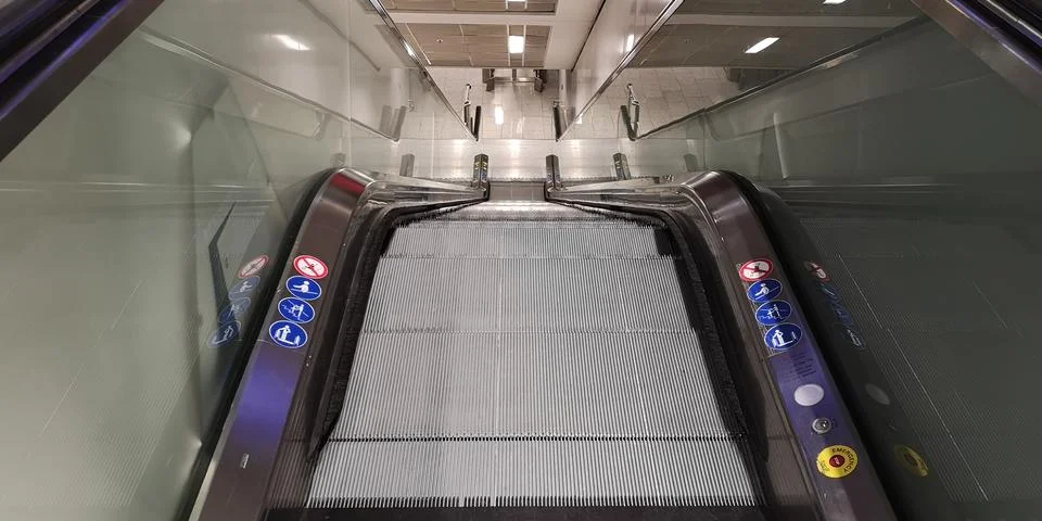Empty escalator leading down between the floors of the Frankfurt airport Stock Photos