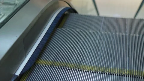 Empty escalator move down low angle view glass sides metal steps yellow line Video stock 223238278
