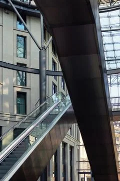 Empty escalator rises inside bright modern commercial atrium with clean steel Stock Photos
