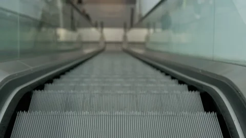 Empty escalator steps moving. Modern interior with glass sides and metal steps. Stock Footage 236723035