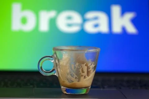 Empty espresso cup on laptop with break message on screen Stock Photos