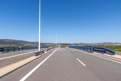 Empty exit from the road bridge against the backdrop of the mountains Stock Photos