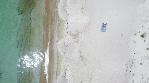Empty exotic sand beach with one young woman sunbathing and relaxing on sunlight Stock Footage 171393641