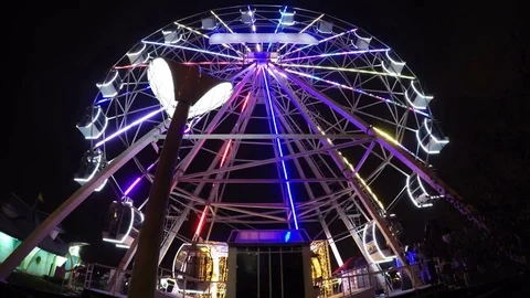 Empty ferris wheel magical attraction spinning at night illuminated LED Stock Footage 83869111