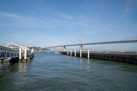 Empty ferry docking station in front of Bay Bridge in California leading to Stock Photos