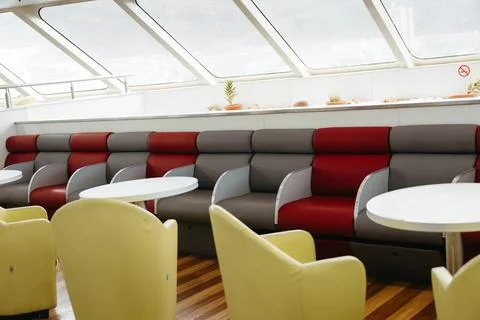 Empty ferry seating area with red and grey chairs Foto stock