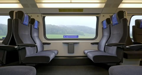Empty first class bench seats inside moving public passenger train in Europe Stock Footage 288457608