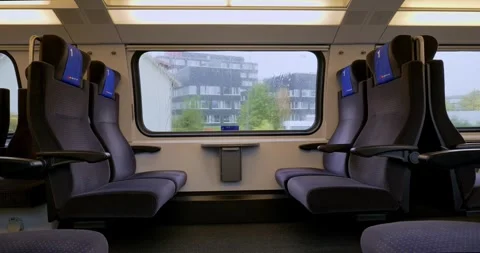 Empty first class bench seats inside moving public passenger train in Europe Stock Footage 288458083