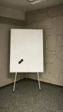 Empty flipchart board set up in classroom with stone wall background. board.. Stock Photos