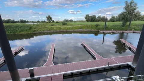 Empty Floating Boat Docks by a Green Riverside Landscape Stock Footage 342278080