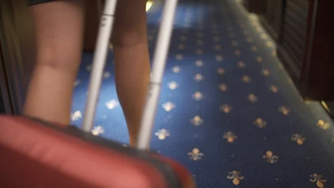 An empty floor, woman's legs walking with a trolley suitcase appear in the shot. Video stock 94984940