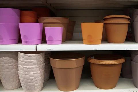 Empty flower pots in a store or greenhouse. Colorful pots for plants. Stock Photos