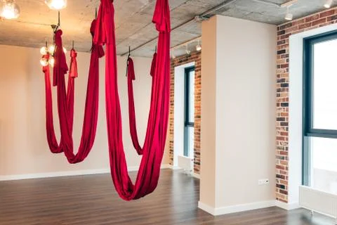Empty flying yoga loft design studio with red hammocks and wooden texture floor. Foto stock