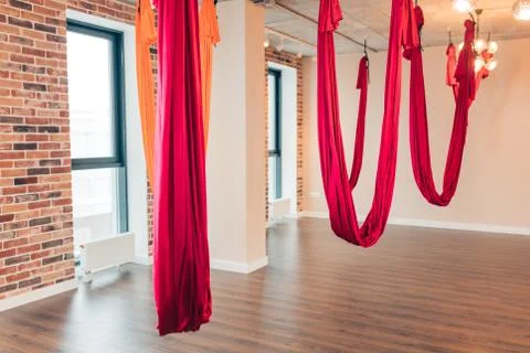 Empty flying yoga loft design studio with red hammocks and wooden texture floor. Foto stock