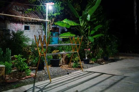 Empty Folding Clothes Drying Rack In Rural Tropical Backyard At Night Stockfoto's