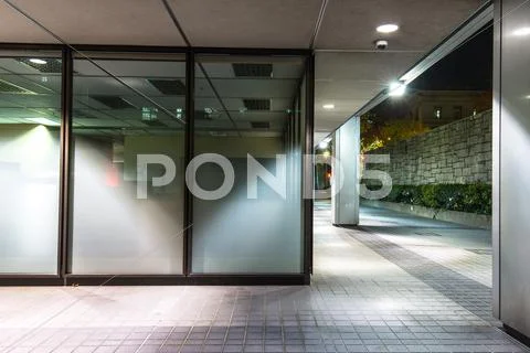 Empty Footpath Front Of Modern Business Building At Night