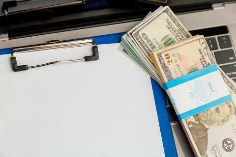 An empty form of documenton the tablet and money isolated on the table. Stock Photos