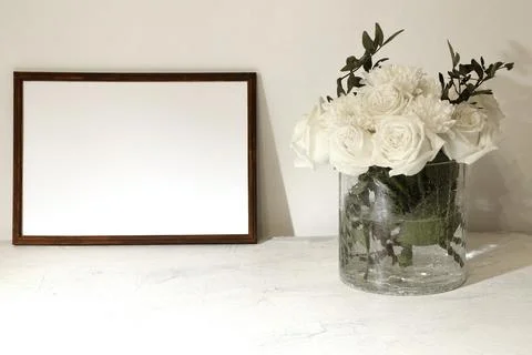 Empty frame and bouquet of white roses on a white background with space for t Stock Photos