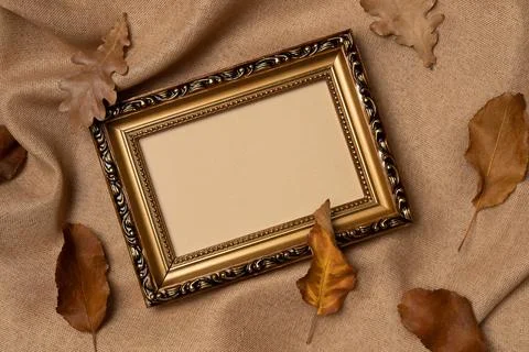 Empty frame with foliage on a fabric background from above. Autumn concept. Stock Photos