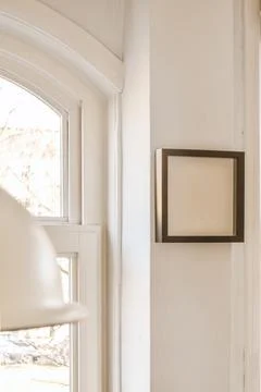Empty frame hanging on wall in modern apartment 스톡 사진